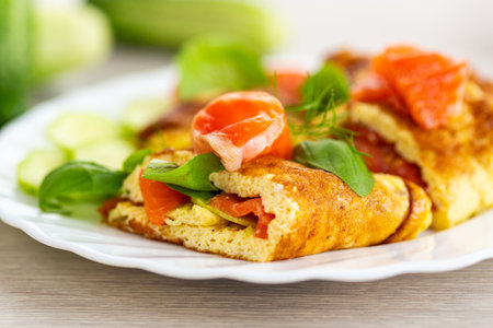 Classic omelet with red fish and fresh vegetables.