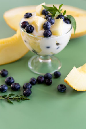 Summer vitamin cream yogurt with melon blueberries and mint.の写真素材