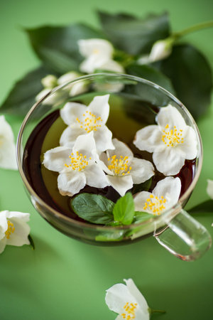 Glass teapot with jasmine and green tea isolated.の写真素材