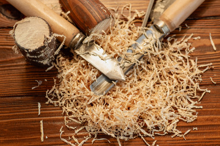Close up of wood carving with sawdust on wooden table.の写真素材