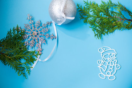 New Year's white ball and snowman on a background with a fir branch.の写真素材