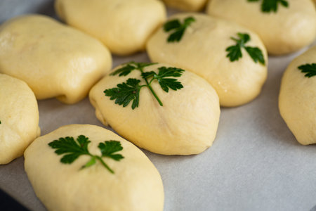 Unbaked dough pieces decorated with parsley ready for oven.の写真素材