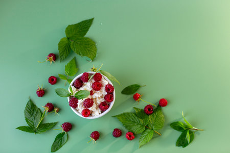 White bowl with cottage cheese and raspberries on the table.