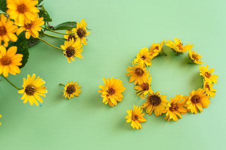 Blooming yellow flowers with natural leaves on green background.の写真素材