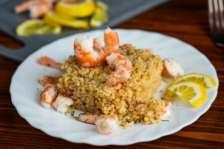 gourmet bulgur with shrimp and herbs on plate.の写真素材
