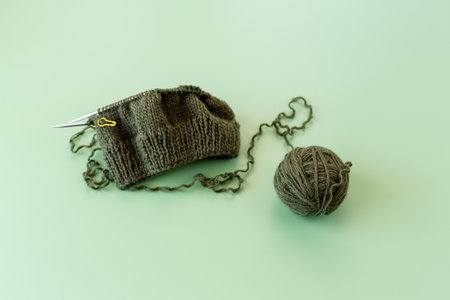 handmade knitting project with yarn ball and knitting needles.