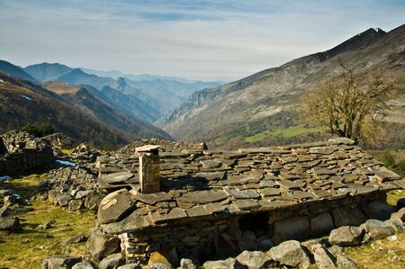 Stone cabin in the mountains overlooking the valleyの写真素材