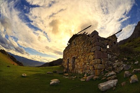 Landscape with an abandoned cabin and a blue sky with clouds.の写真素材