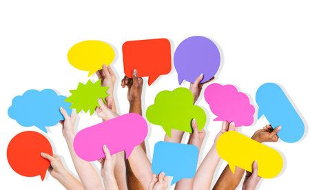 Group of human arms raised with multi colored speech bubble 