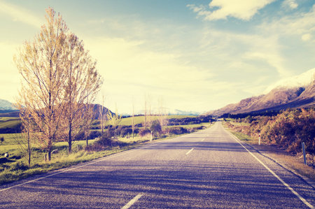 Autumn themed country road with mountain range as a background.