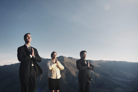 Business Team Meditating On Top of the Mountains Concept