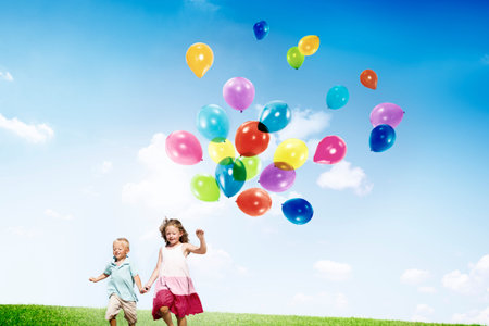 Little Girl and Boy Outdoors Holding Balloons Concept