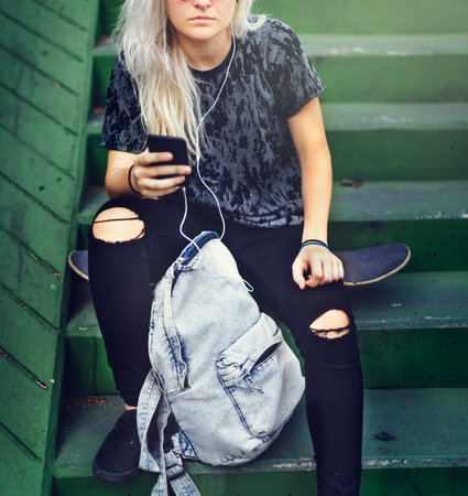 Young Woman Skater Browsing Phone Concept
