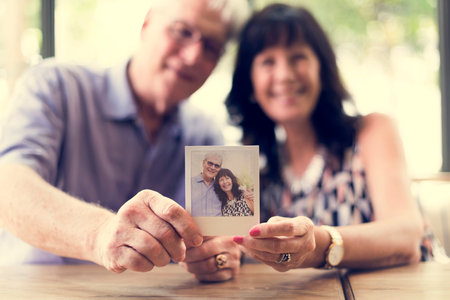 Close up couple showing instant camera image