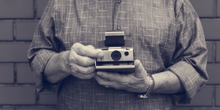 Photo pour Person holding a retro instant camera - image libre de droit