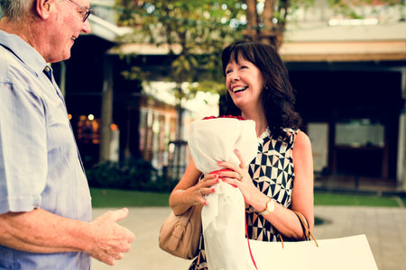 Senior couple woman holding bouquet of roses