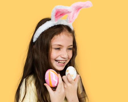 Kid with a bunny hairband holding eggs