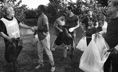 Diverse Group of People Picking Up Trash in The Park Volunteer Community Service