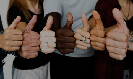 Group of people thumbs up together