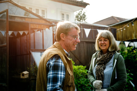 Senior couple planting vegetables at garden backyard