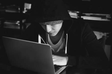 Young asian boy wearing hoodie using digital laptop