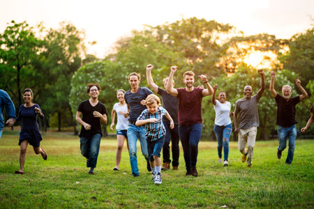 Group of people walking and running playful in the park