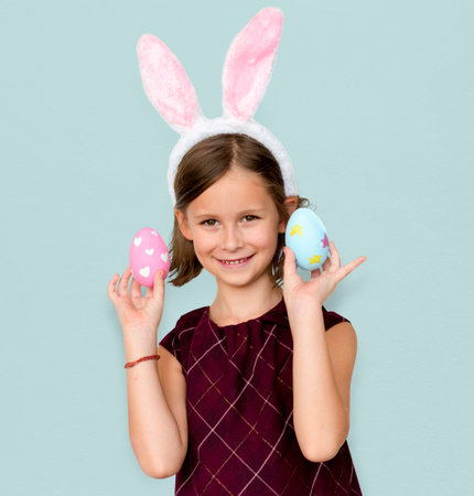 Kid with a bunny hairband holding eggs