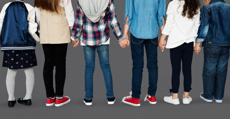 Group of diverse kids students standing in a row holdings hands