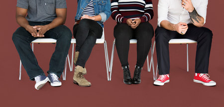 Lower section of people sitting on chairs