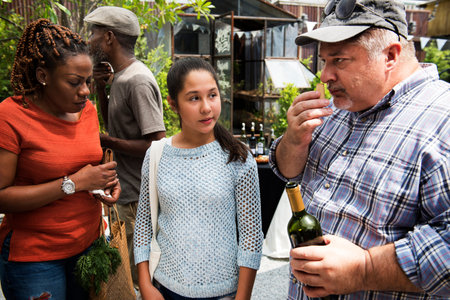 Man Offering Red Wine to Senior Men Food Stall