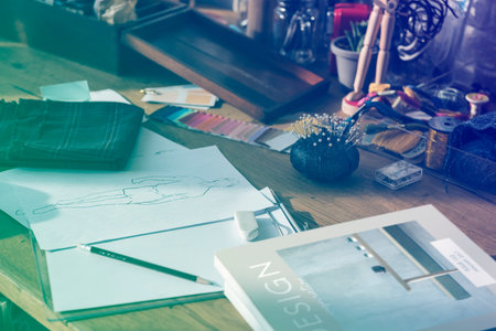 Wooden table with messy objects and sketch book