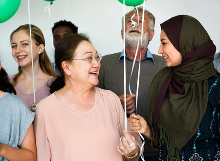 People standing in group holding balloons posing for photoshoot