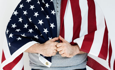 Person standing and holding country flag around the shoulder