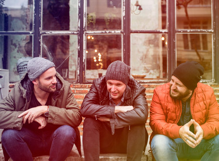 Group of men sit and talk outdoors in winter