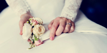 Attractive Beautiful Bride Showing Engagement Wedding Ring on Hand and Flower Bouquet