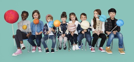 Diverse group of kids holding planets on sticks isolated background