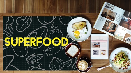Breakfast meal on a wooden table and blackboard with vegetable icon