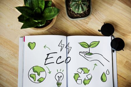 Laid out book with environmental sketch on wooden table