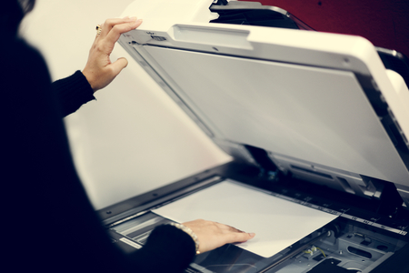 Woman using machine to copy document