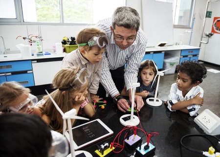 Diverse kindergarten students learning energy producer from solar windmill in science class