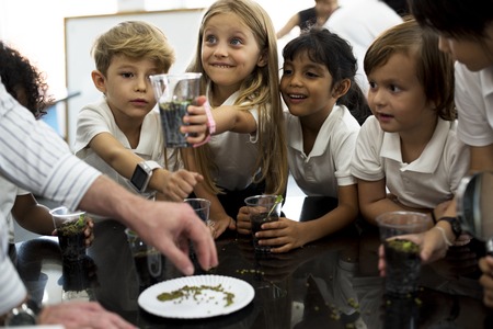 Group of diverse kindergarten students learning planting in science class