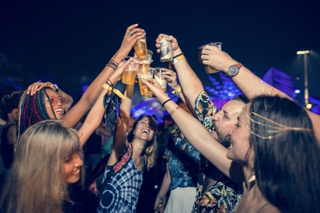 Group of Friends Drinking Beers Enjoying Music Festival Together