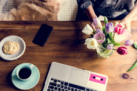 Florist woman decorates the flower on wooden table