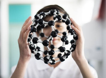 High school student hands holding molecul structure in chemistry class
