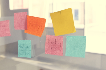 Sticky note reminder on bulletin board glass