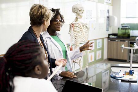 Biology teacher teaching anatomy with diverse high school students