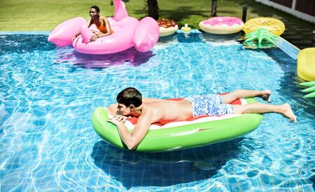 Teenager floating on life ring in swimming pool