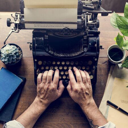Hands typing on classic vintage typewriter