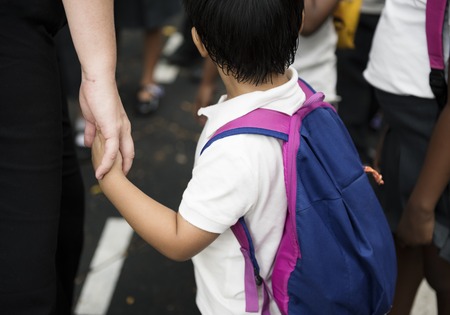 Kindergarten student holding hands with adult