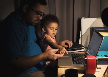 Man carrying the kid while working on laptop